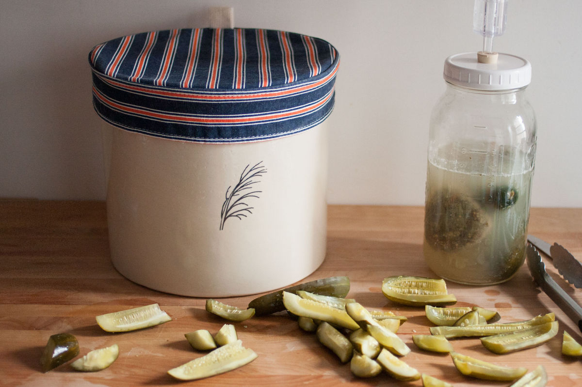Pickles in front of a crock and a jar