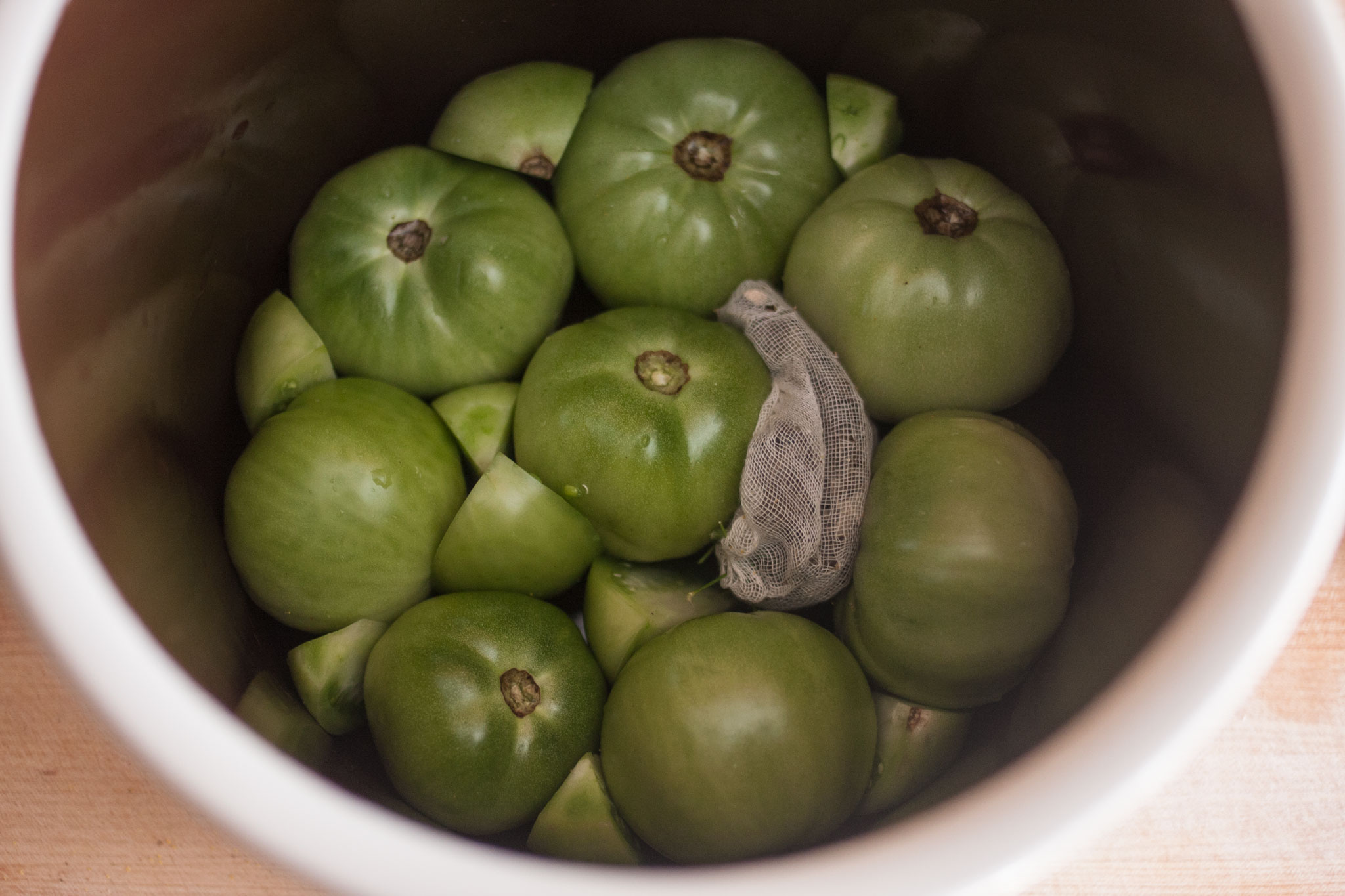 Green tomatoes in a fermentation crock Kirby & Kraut