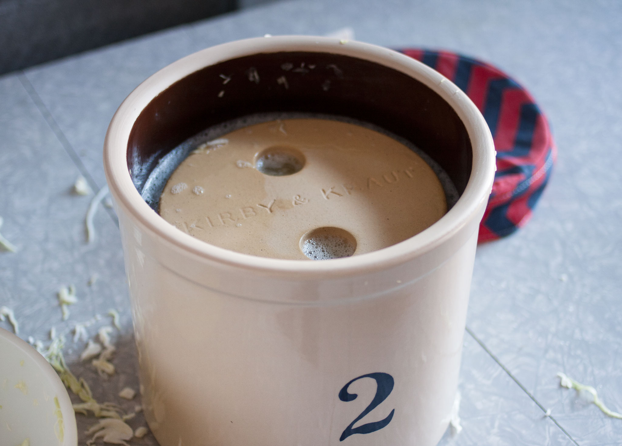 Weighing down sauerkraut with a crock weight Kirby & Kraut